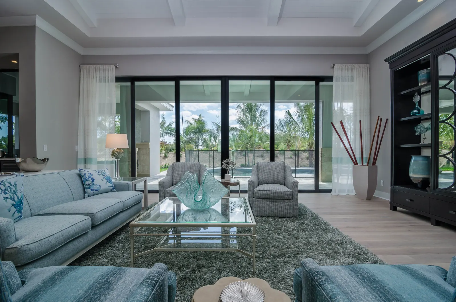 Living room pool view at The Captiva Model, a custom home built by Marvin Homes in Naples, Florida