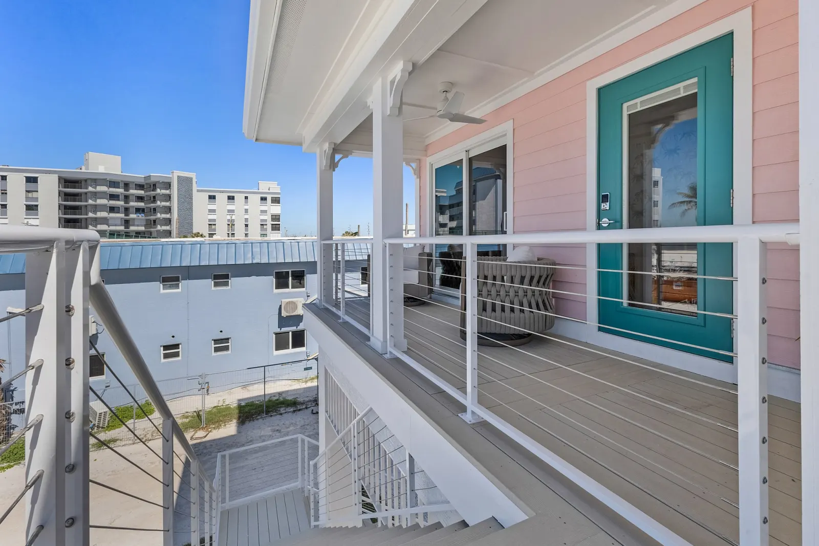 Deck entry teal door at The Flamingo, a custom home built by Marvin Homes in Fort Myers Beach, Florida