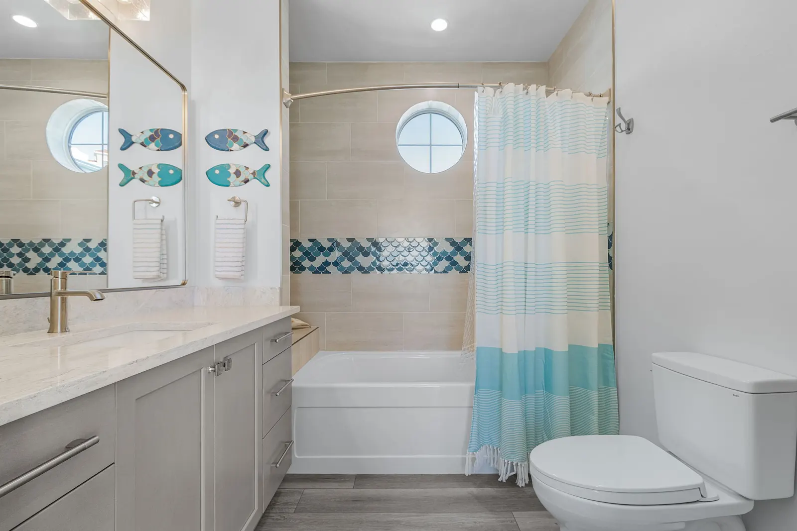 Bathroom tub shower fish decor at The Marlin, a custom home built by Marvin Homes in Cape Coral, Florida
